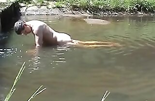 Cumming above a stone in a river